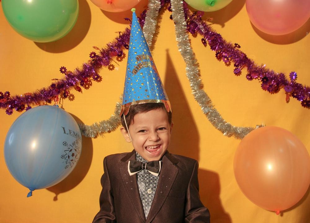 a child wearing a birthday hat at his birthday party
