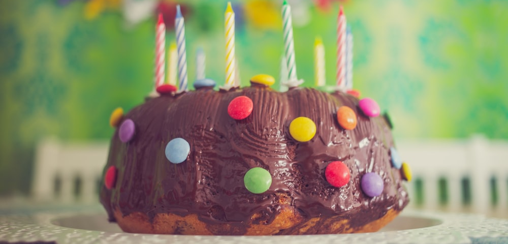 a chocolate cake with colorful candles and M&M