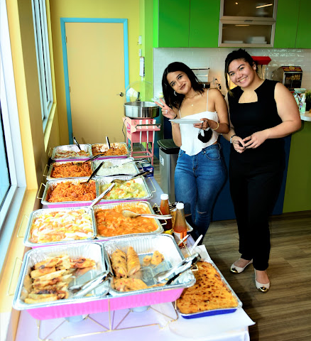 Two women standing by a food station at a baby shower at BirthdayLand