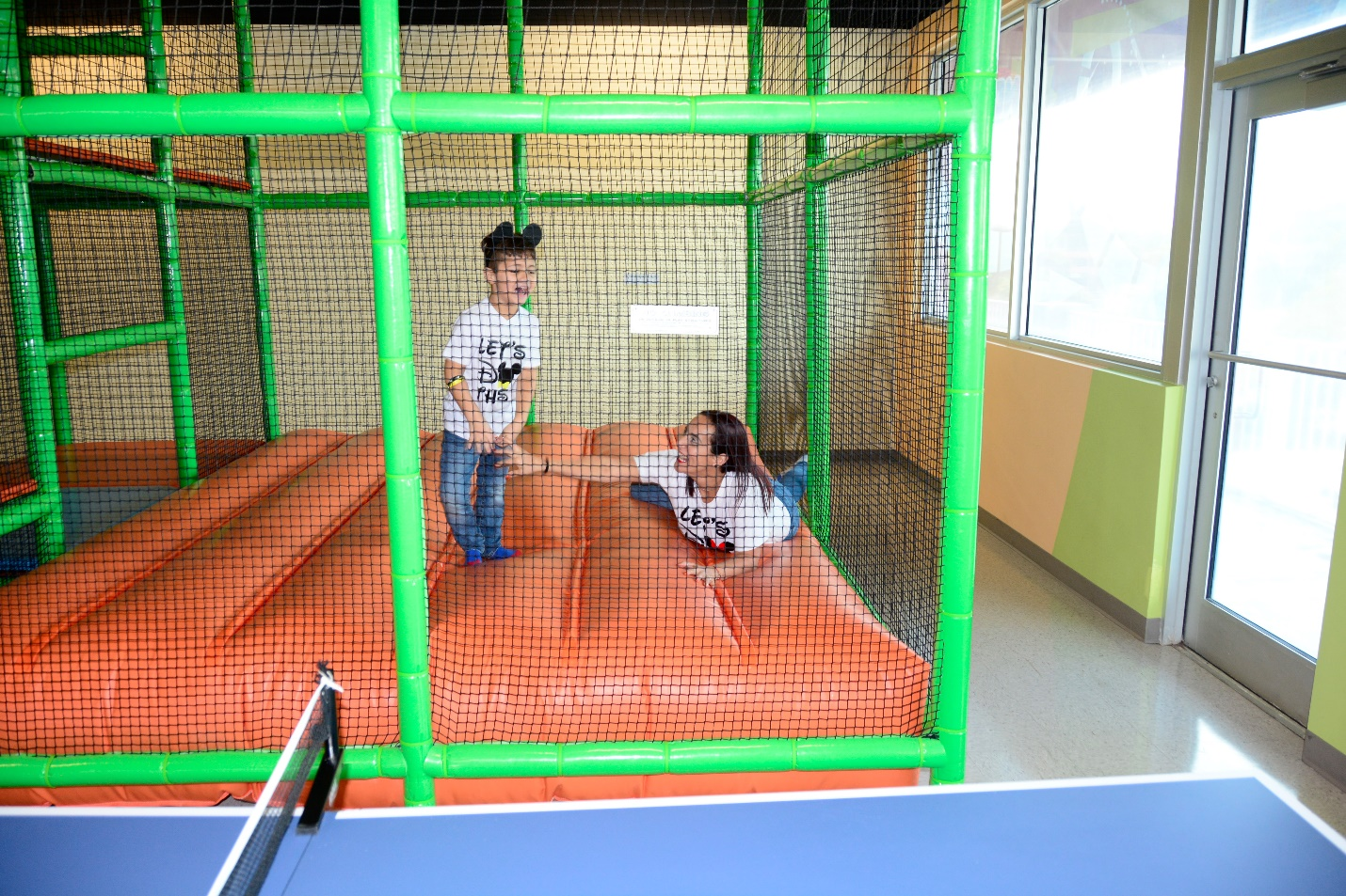 : a child and parent enjoying an indoor bounce house