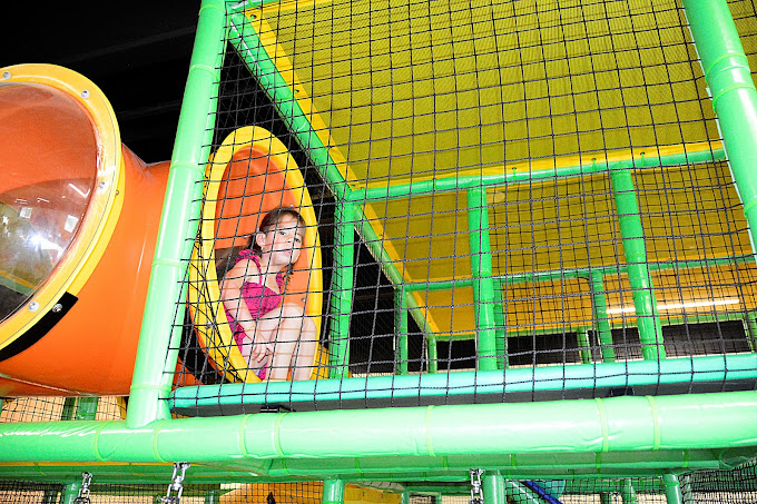 A little girl enjoying the indoor playground rides at a kids’ party at BirthdayLand