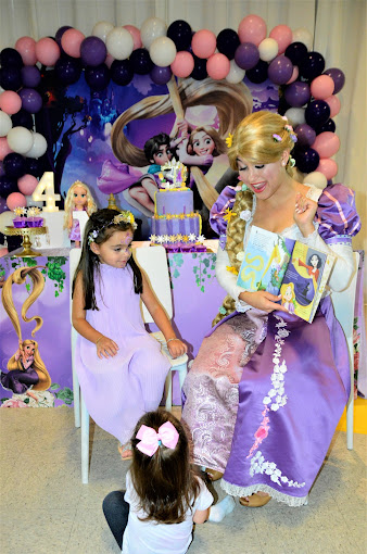 Little girls sitting with an artist dressed as Rapunzel and telling stories at BirthdayLand