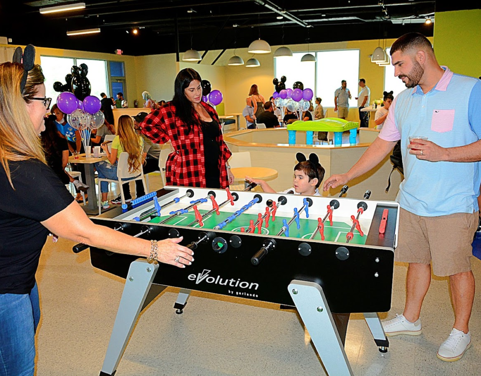 A woman and a kid playing foosball