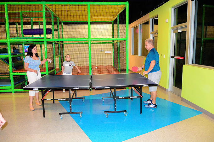 A man and a woman playing ping pong at a birthday party at BirthdayLand