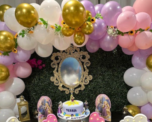 Birthday decorations with pink, white, and gold balloons