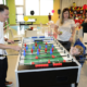 A dad playing foosball with his kid