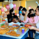 A young girl taking food on her plate at a birthday celebration at BirthdayLand
