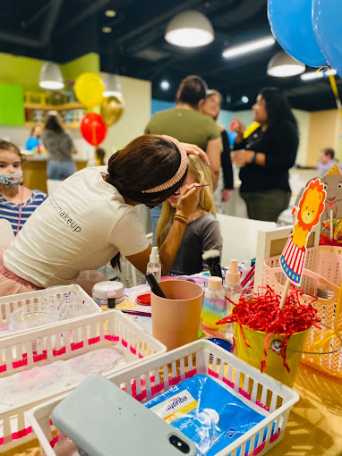 A n artist face-painting a kid at a birthday celebration at BirthdayLand 